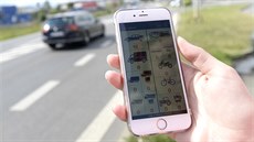 Pracovnice ukazuje aplikaci v mobilním telefonu pro poítání automobil ve...