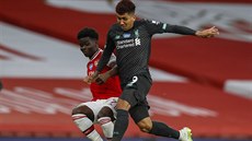 Bukayo Saka (vlevo) z Arsenalu v souboji s Robertem Firminem z Liverpoolu.