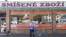 Žena s nasazenou rouškou stojí před obchodem v Církvici na Kutnohorsku, kde ve...