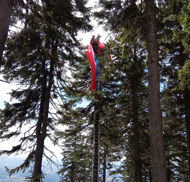 Paraglidista na erné hoe v Krkonoích se dostal ze stromu po ebících...