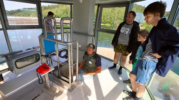 Vodn� n�dr� Horka. Vedouc� hr�zn� Martin Uhl�k (uprost�ed sed�c�) vede exkurzi ve v�i u p�epusti nad hladinou.