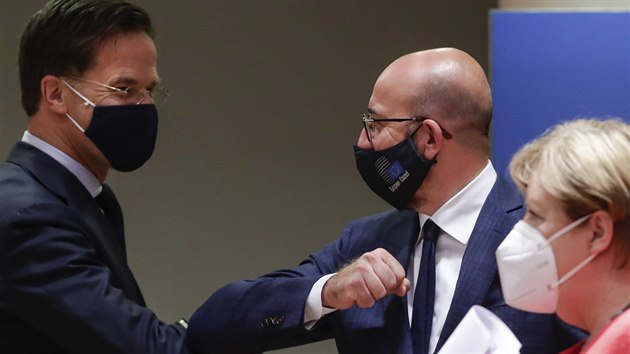 Nizozemsk premir Mark Rutte (vlevo) se zdrav s fem Evropsk rady Charlesem Michelem, kolem prochz nmeck kanclka Angela Merkelov. (21. ervence 2020)
