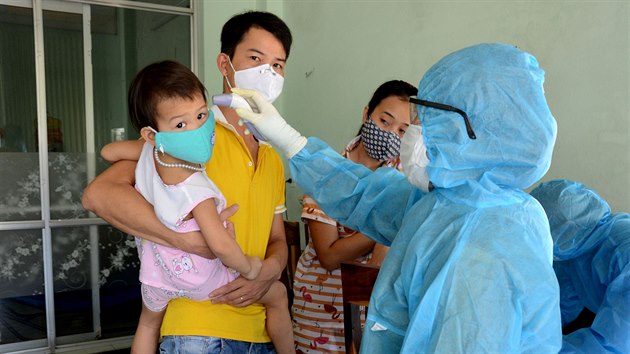 Zdravotnk m teplotu obyvatelm ve vietnamskm mst Danang, kde se objevily nov ppady koronaviru. (26. ervence 2020)