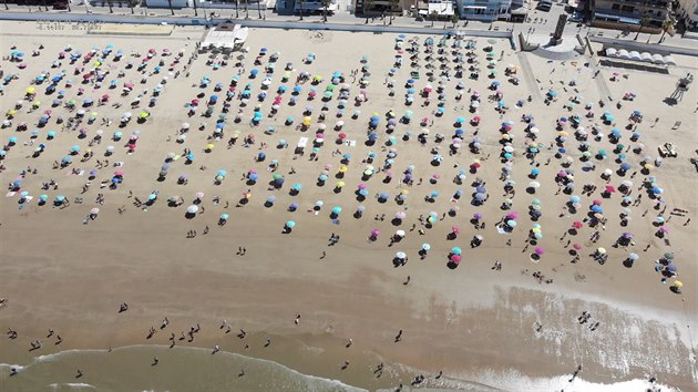 Návštěvníci pláže ve španělském městě Chipiona dodržují sociální vzdálenost. (25. července 2020)