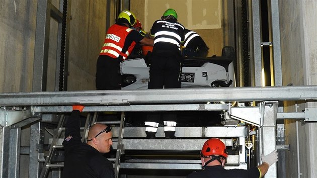 Pražští hasiči a policisté museli z výtahové šachty vytáhnout auto i s jeho řidičem. (22.července 2020)