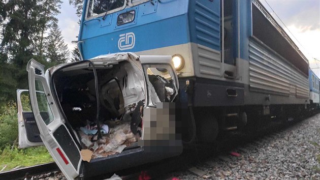 Vrak auta zůstal zaklíněný pod vlakem po střetu vlaku s automobilem na nechráněném železničním přejezdu v Borohrádku na Rychnovsku. (21. července 2020)