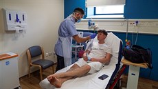 Britský zdravotník testuje pacienta na koronavirus.  (27. kvtna 2020)