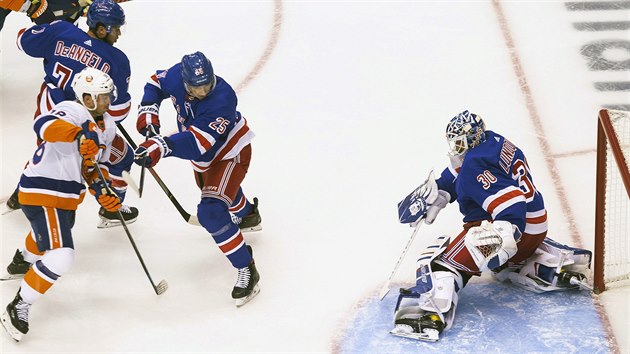 Libor Hjek (. 25) z New York Rangers brn Anthonyho Beauvilliera  z New York Islanders, aby neohrozil branke Henrika Lundqvista.