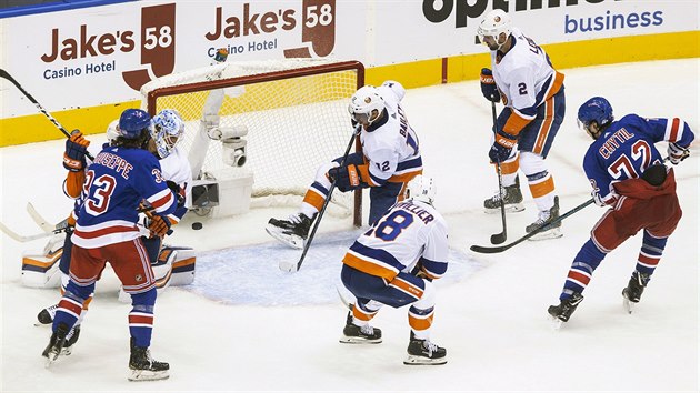 Filip Chytil (vpravo) z New York Rangers překonává brankáře Thomase Greisse z New York Islanders.
