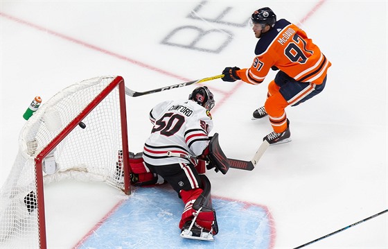 Connor McDavid z Edmontonu pekonává Coreyho Crawforda v brance Chicaga.