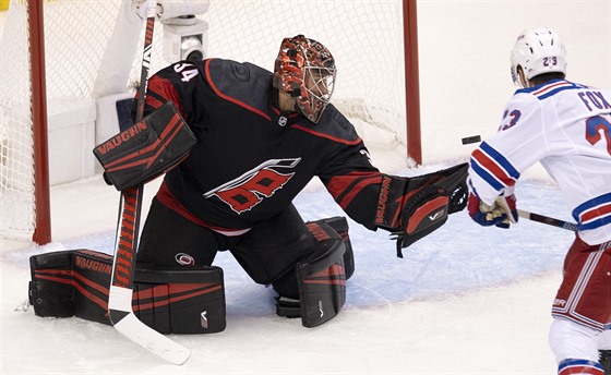 Adam Fox z NY Rangers zkouí pekonat Petra Mrázka v brance Caroliny.