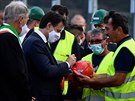 Italský premiér Giuseppe Conte podepisuje helmu stavam, kteí se podíleli na...