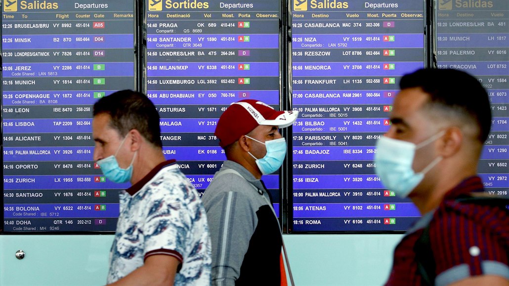 Cestující v rouškách na mezinárodním letišti ve španělské Barceloně (26....