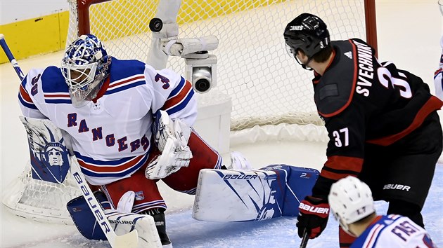 Andrej Sve�nikov z Caroliny sleduje puk, kter� m��� do branky Henrika Lundqvista z NY Rangers.