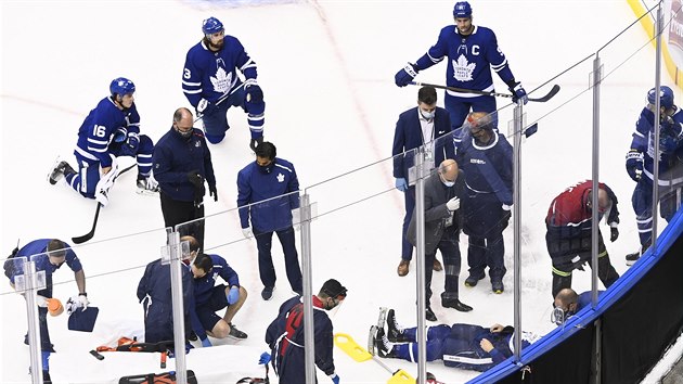 Tým Toronto Maple Leafs sleduje ležícího spoluhráče Jakea Muzzina, kterého opečovávají lékaři po nárazu do hlavy.