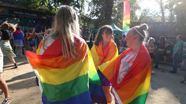 Účastníci festivalu Prague Pride zahalení v duchových vlajkách symbolizujících LGBT komunitu. (8. srpna 2020)
