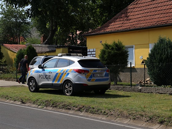 Zpoza uzavené vstupní branky, kterou hlídali policisté v uniform, se nkolik...