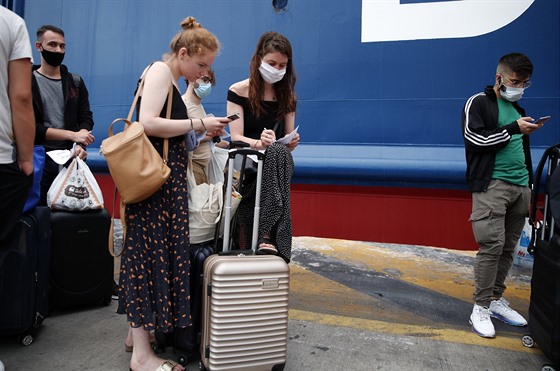 Turisté vyplňují zdravotnický dotazník kvůli koronaviru před vstupem na trajekt...