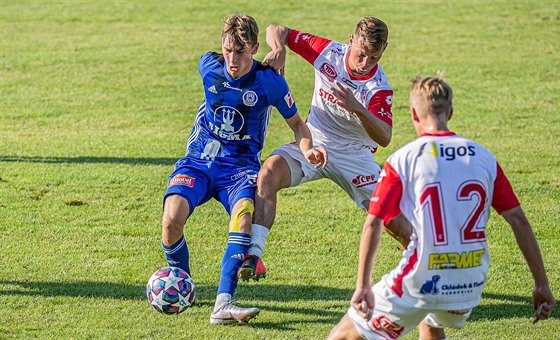 Obránce Pardubic Michal Surzyn (uprosted) bojuje se soupeem o balon v utkání...