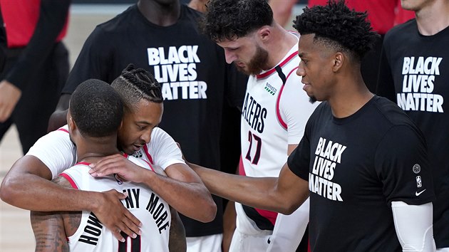 Damian Lillard (z�dy) v objet� par��ka z Portlandu CJ McColluma po postupu do...