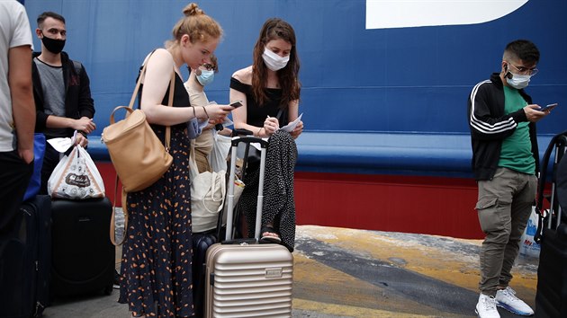 Turisté vyplňují zdravotnický dotazník kvůli koronaviru před vstupem na trajekt v řeckém přístavu Pireus. (7. srpna 2020)