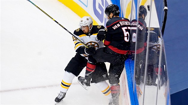 Brad Marchand (vlevo) z Bostonu atakuje Trevora van Riemsdyka z Caroliny.