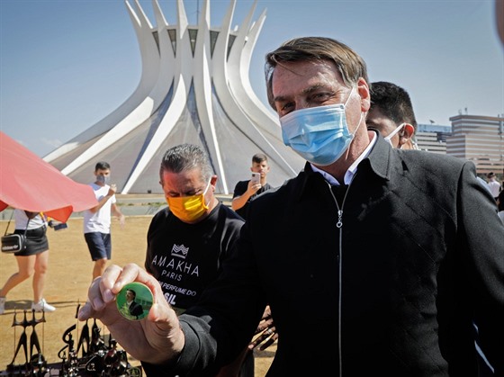 Brazilský prezident Jair Bolsonaro drží odznáček se svou podobiznou. (23. srpna...