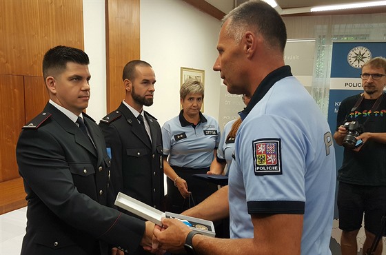 Krajský policejní ředitel Tomáš Kužel (vpravo) předává ocenění policistovi...