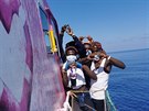 Migranti pózují na lodi Louise Michel, urené k záchran migrant ve...