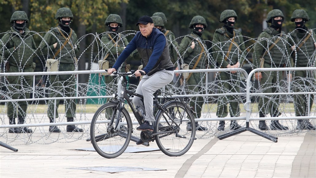 Mu na kole projídí kolem policejního kordonu v bloruském Minsku. (23. srpna...