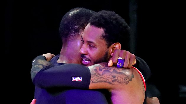 LeBron James (vlevo) s Los Angeles Lakers postupuje, gratuluje mu jeho velk kamard Carmelo Anthony z Portland Trail Blazers.