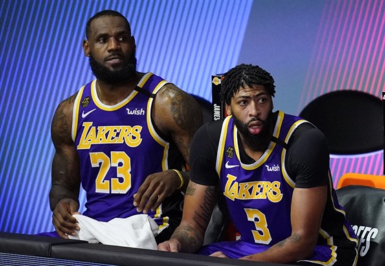 LeBron James (vlevo) a Anthony Davis z Los Angeles Lakers sledují z laviky...