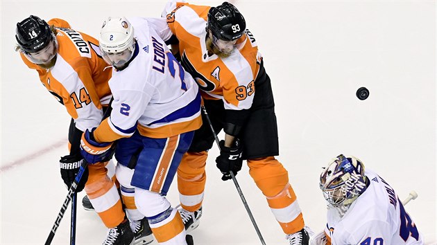Jakub Vorek a Sean Couturier z Philadelphia Flyers se sna teovat puk ped brankem New York Islanders Semjonem Varlamovem, ktermu ist vhled Nick Leddy.