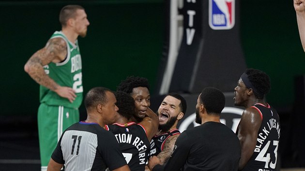 Basketbalist Toronto Raptors slav vtznou trefu O. G. Anunobyho, v pozad bostonsk Daniel Theis.