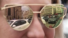 Automobily se odráejí v brýlích návtvnice velkého evropského srazu...