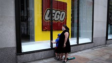 Žena s dítětem za výkladem uzavřené prodejny stavebnic Lego v Rockefellerově...