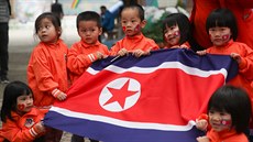Dti drí ve kolce severokorejskou vlajku. (27. února 2019)