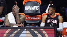 P. J. Tucker (vlevo) a Russell Westbrook sedí zklaman na lavice, u tuí, e...