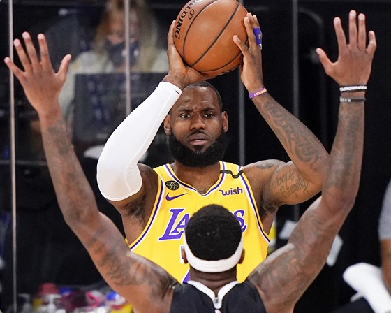 LeBron James (nahoe) z LA Lakers pihrává pes Torreyho Craiga z Denveru.