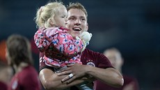Sparťanský útočník Lukáš Juliš s dcerou oslavuje ligové vítězství s fanoušky.