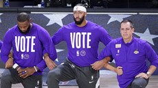 LeBron James, Anthony Davis a trenér Frank Vogel (zleva) z LA Lakers klečí při...