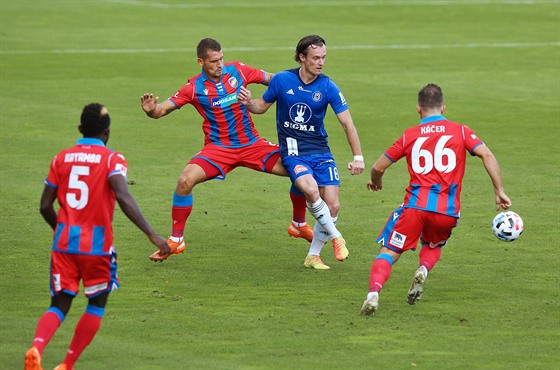 Martin Nepor (v modrém) z Olomouce hraje balon, zatímco je v obleení hrá...