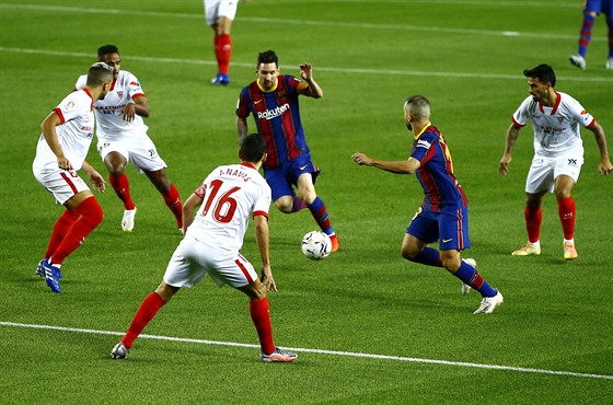 Lionel Messi (u balonu) z Barcelony postupuje pes hráe Sevilly.