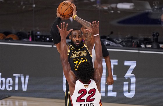 LeBron James (23) z LA Lakers pihrává pes Jimmyho Butlera (22) z Miami.