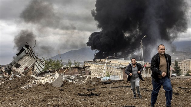 Muži utíkají z arménského města Stěpanakert, který raketami ostřeluje armáda sousedního Ázerbájdžánu. (4. října 2020)