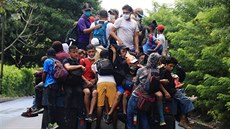 Honduratí migranti se vezou na korb nákladního auta v Guatemale. (1. íjna...