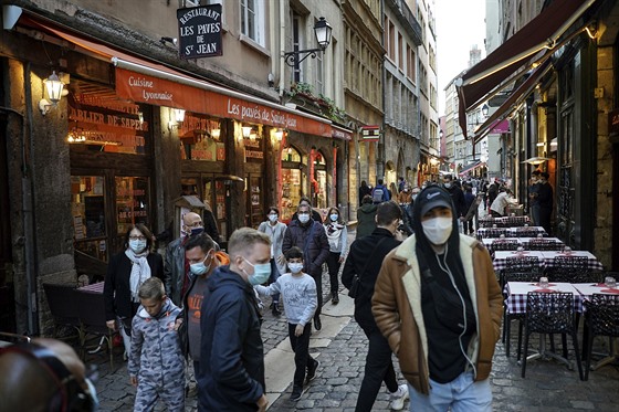 Lidé v rouškách procházejí kolem restaurací v centru francouzského Lyonu. (10....
