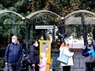 Lidé v roukách na autobusové zastávce Stará osada v Brn. (13. íjna 2020)