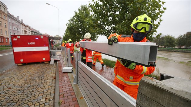 Profesionální hasiči sestavují v Přerově u rozvodněné řeky Bečvy mobilní protipovodňové hrazení.