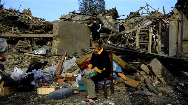 ena sed v troskch domu zasaenho bhem boj o Nhorn Karabach. (11. jna 2020)